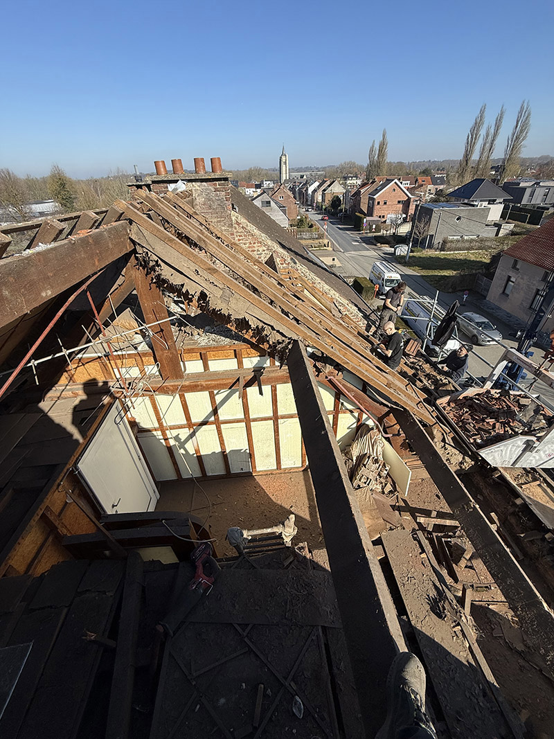 Voor de dakrenovatie in Zottegem, zichtbaar met versleten pannen en aangetaste houten structuur