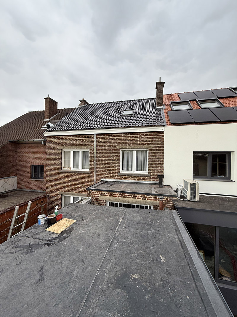 Na de dakrenovatie in Zottegem, afgewerkt met donkergrijze dakpannen en nette aansluitingen